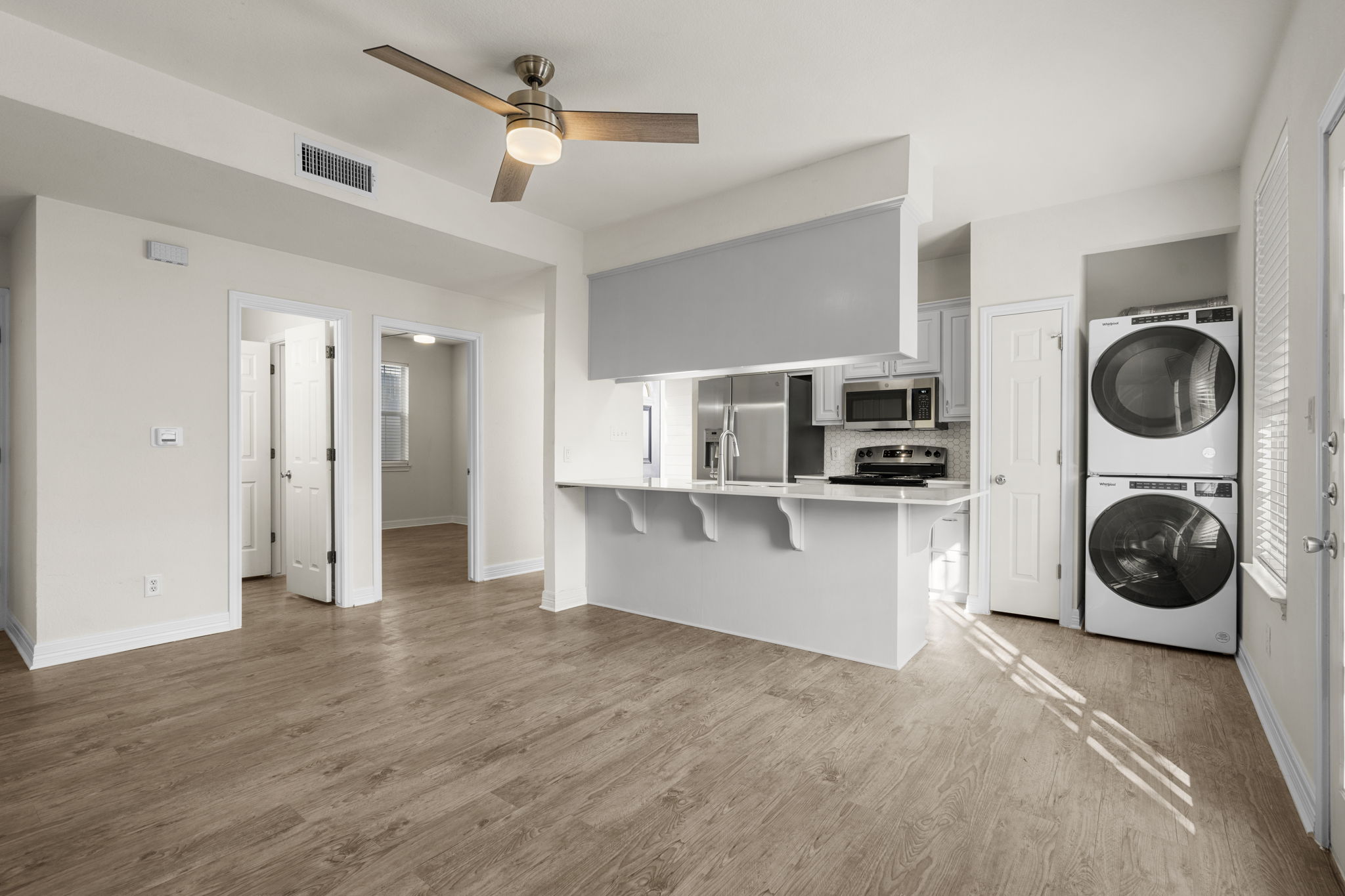 Bright living room with natural light and French door to private balcony — Whitestone West Campus student apartment