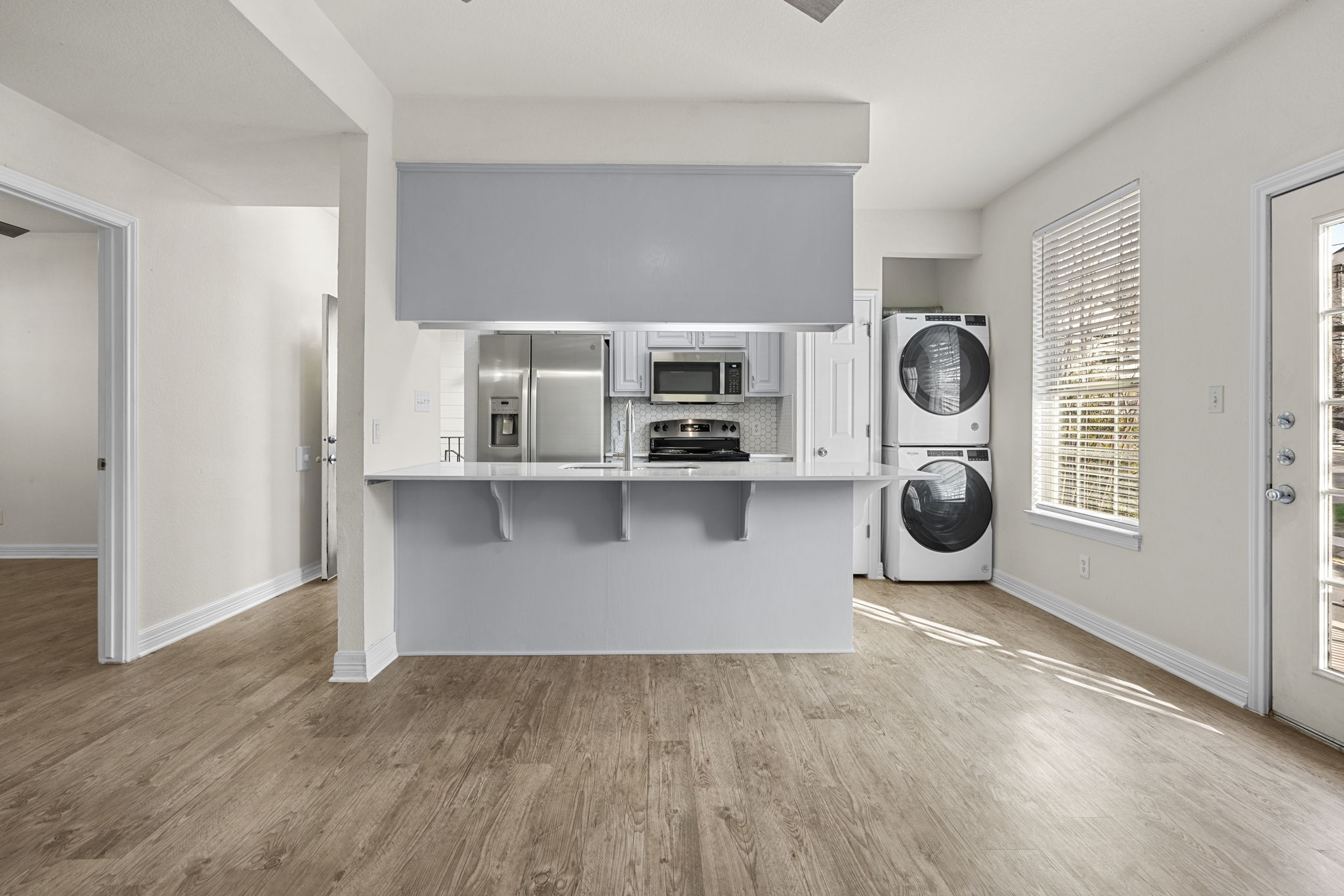 Living room with kitchen peninsula and French door — 3-bedroom student apartment at 2500 Leon Street Austin TX